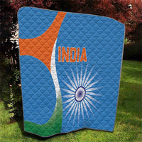Blue cricket quilt blanket with India text and sunburst wheel; orange-white emblem and green corner