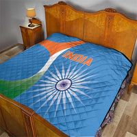 Blue cricket quilt blanket laid on bed with India text, sunburst wheel, and orange-white emblem