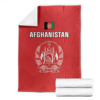 Folded red Afghanistan flag cricket blanket with white crest and “AFGHANISTAN”, with rolled towels