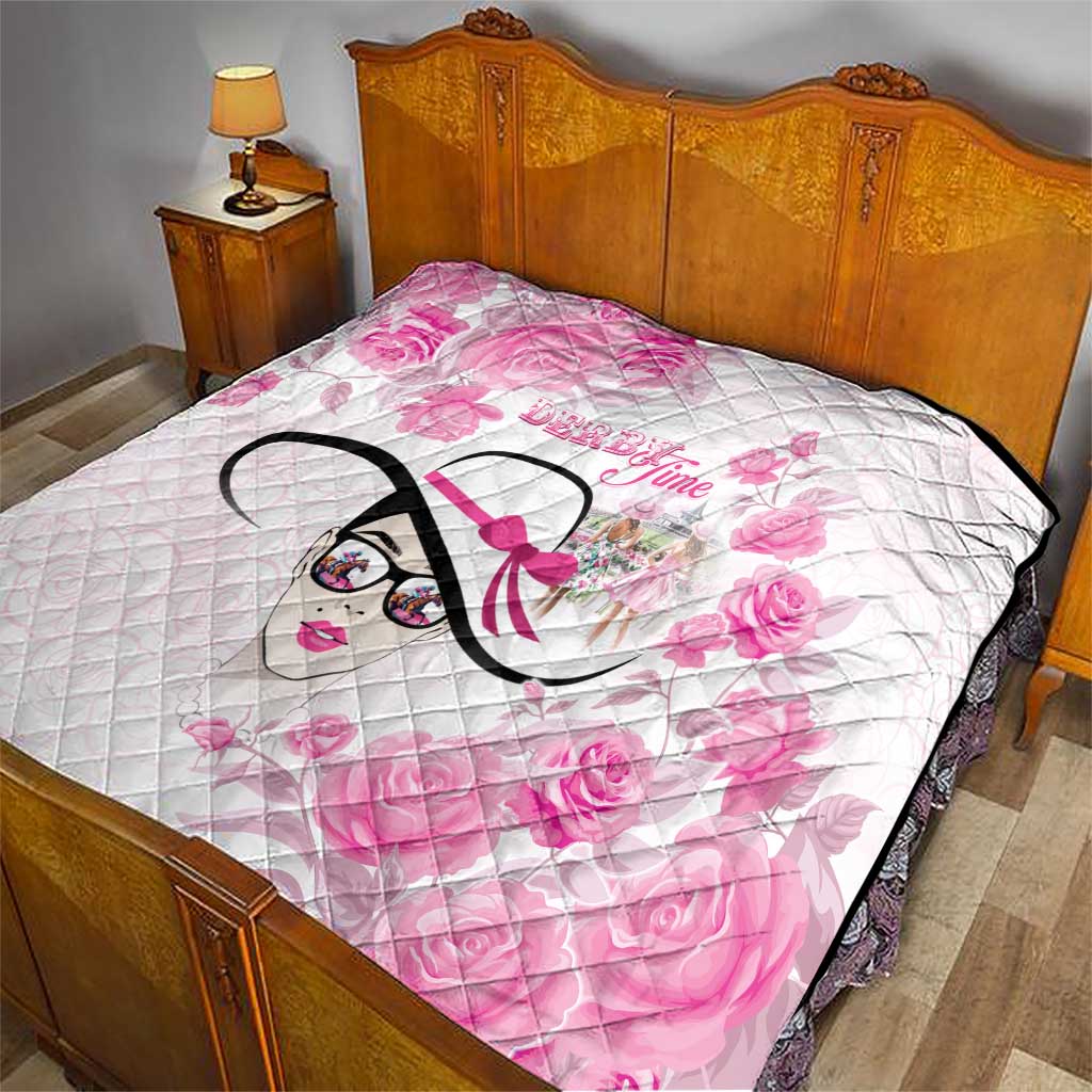 Pink floral quilt laid on bed, diamond quilting, stylized woman face graphic with black border