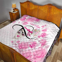 Pink floral quilt laid on bed, diamond quilting, stylized woman face graphic with black border