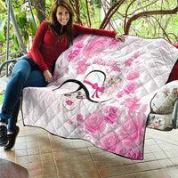Pink floral quilt draped on couch, diamond quilting, stylized woman face graphic, black trim