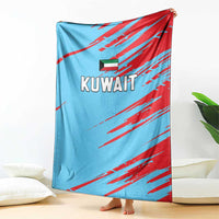 Kuwait cricket blanket draped on floor, light blue with red stripes and Kuwait text