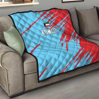 Kuwait cricket quilt blanket on sofa, blue and red quilt with Kuwait logo in center.