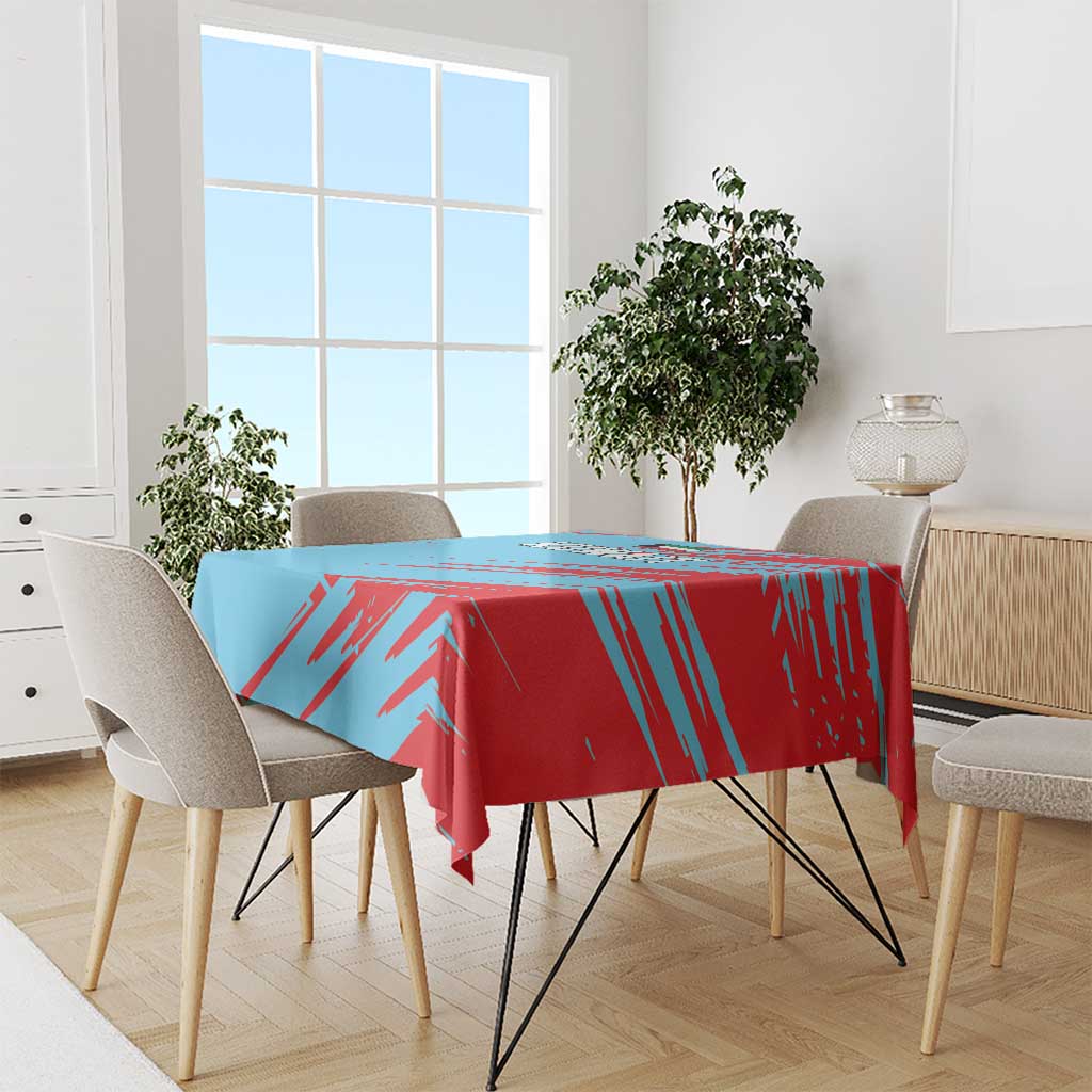 Blue and red Kuwait graphic tablecloth draped over dining table with matching overhang