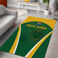 Rectangular green South Africa area rug, yellow trim, flag emblem and protea floral center