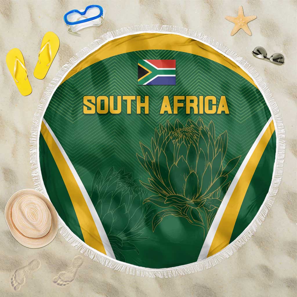 Green South Africa beach blanket with fringed edge, flag, “SOUTH AFRICA” and protea design