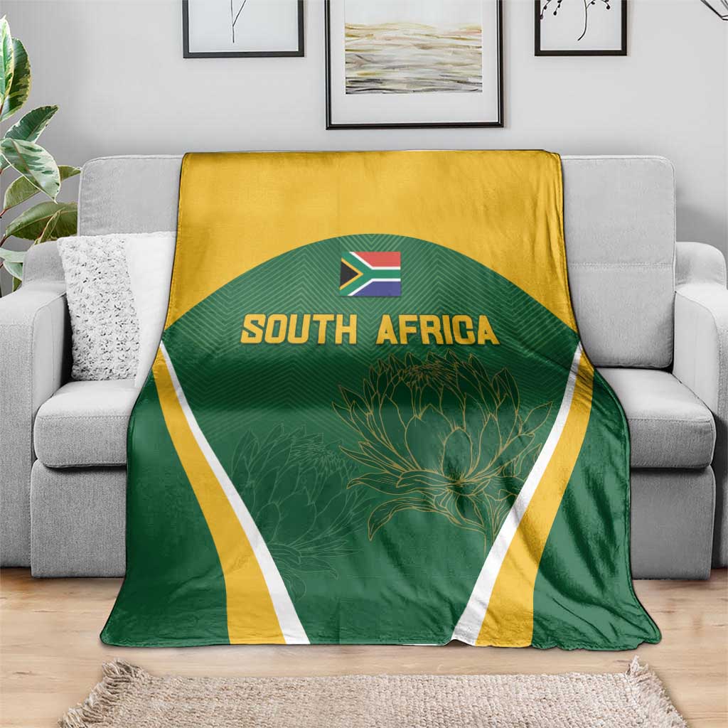 South Africa cricket blanket draped on sofa, green center with gold top and white trim