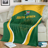 South Africa cricket blanket on armchair, green shield graphic with gold band and white edging