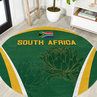 Green round carpet with SOUTH AFRICA text, South Africa flag, protea graphic, yellow border