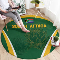Green round carpet with SOUTH AFRICA text, flag and protea print, yellow and white trim
