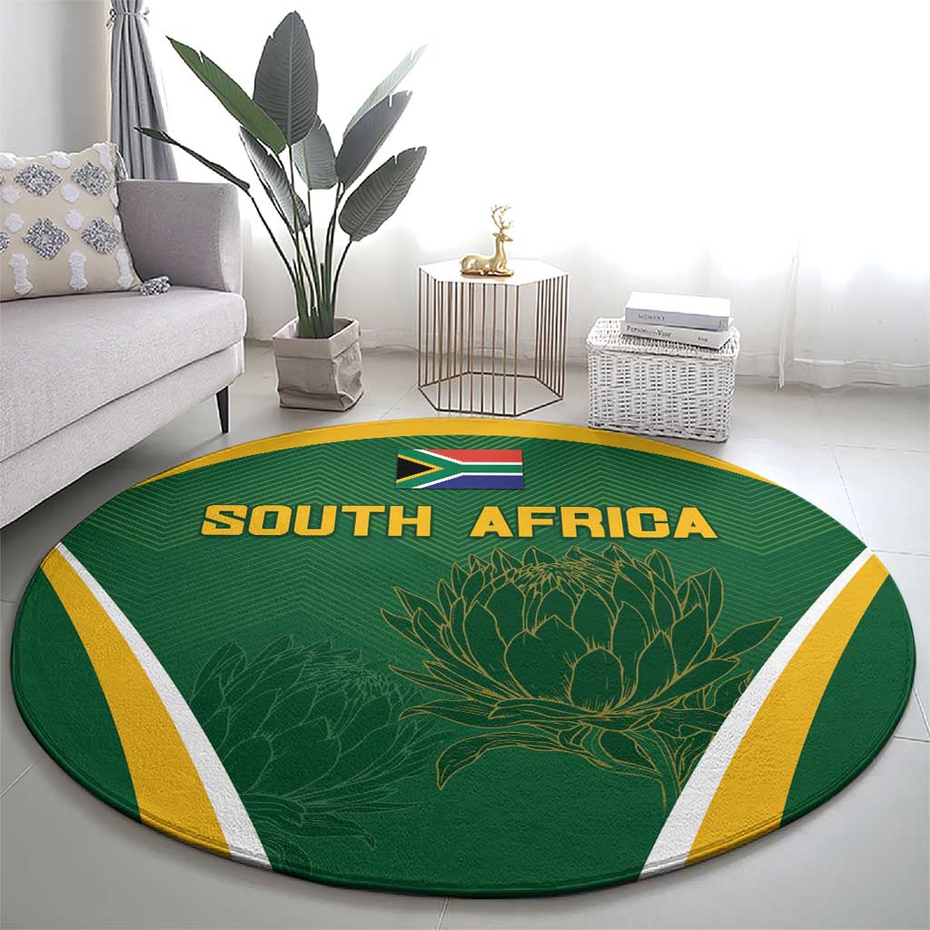 Green round carpet with SOUTH AFRICA lettering, flag and protea design, yellow border