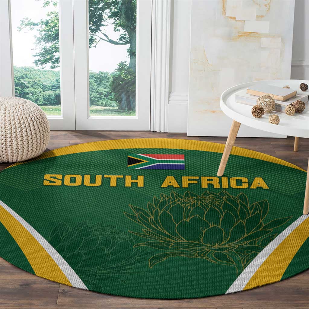 Green round carpet with SOUTH AFRICA text, flag and protea motif, yellow and white edges