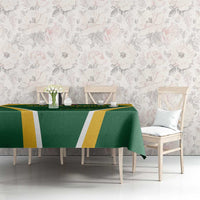 Green dining tablecloth with yellow and white stripe design and protea emblem at center