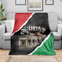 Libya independence day blanket draped on a gray couch, black red green emblem