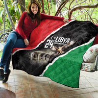 Libya quilt held outdoors with black, red, and green sides and central emblem