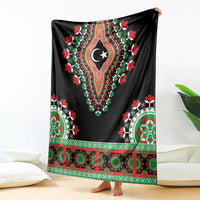 Black dashiki blanket spread out, crescent-star centerpiece with floral green-red trim