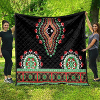 Black quilted throw blanket spread out, featuring red-green floral border and central star emblem.
