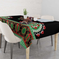 Black tablecloth draped on dining table with green patterned band and floral designs