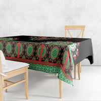 Black tablecloth with green and red geometric band, draped over table edge