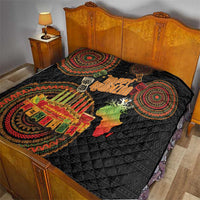 Black Kwanzaa quilt on a bed with circular tribal medallions, “Happy Kwanzaa,” and Africa candle motif