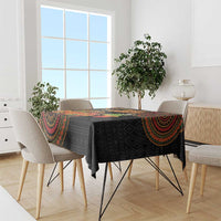 Black tribal-pattern tablecloth with colorful border, draped over a dining table