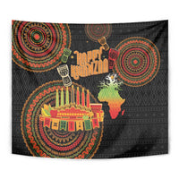 Close-up black tapestry with colorful circular ornaments, menorah candles, and Happy Kwanzaa
