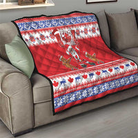 Red Christmas quilt on gray couch with blue-and-white trim, Merry Christmas and Santa