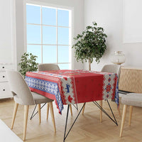 Red and blue holiday tablecloth with geometric knit pattern and festive animal icons