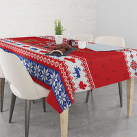 Red holiday tablecloth with blue snowflake-knit border and Santa reindeer print