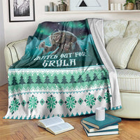 Green Christmas blanket with Gryla graphic, stars, trees, and snowflake border