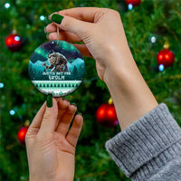 Round ceramic Christmas ornament with Gryla design, held by hand on a tree