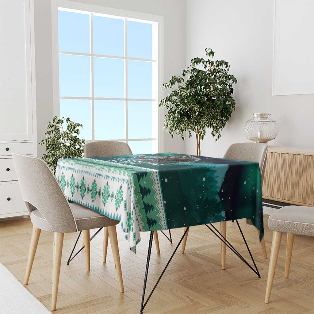 Green and teal tablecloth with pine tree and snowflake border pattern on dining table