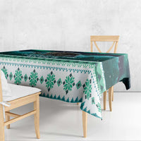 Green and teal tablecloth with geometric snowflake design along the hanging edge