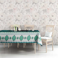 Green and teal tablecloth featuring pine-tree and snowflake motifs on a dining table