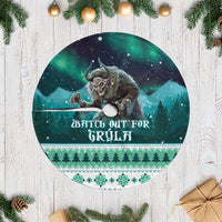 Green round Christmas tree skirt with white fringed edge and printed wolf scene
