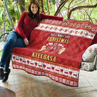 Red Christmas quilt held outdoors with border pattern and sausage graphic and text