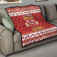Red Christmas quilt draped over sofa with diamond stitching and sausage holiday print