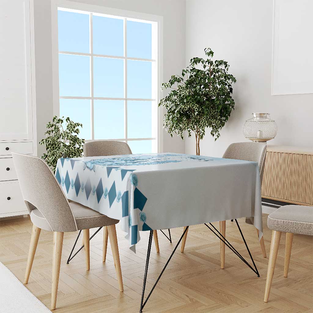 Blue diamond-pattern tablecloth draped over dining table with side overhang