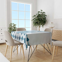Blue diamond-pattern tablecloth draped over dining table with side overhang