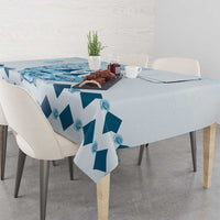 Blue diamond-pattern tablecloth with front corner drop on dining table