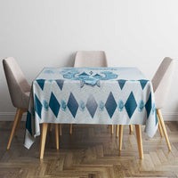 Blue and white diamond-pattern tablecloth centered on dining table with chairs