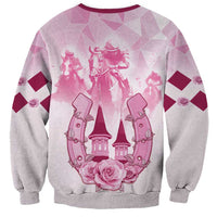 Pink and gray sweatshirt with burgundy trim and horse-racing crest graphic