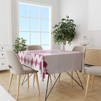 Pink and white tablecloth with repeating diamond pattern and small rose details on table