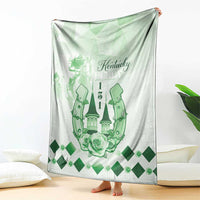 Green and white blanket with Kentucky Derby text, horse silhouettes, roses, and diamond pattern.