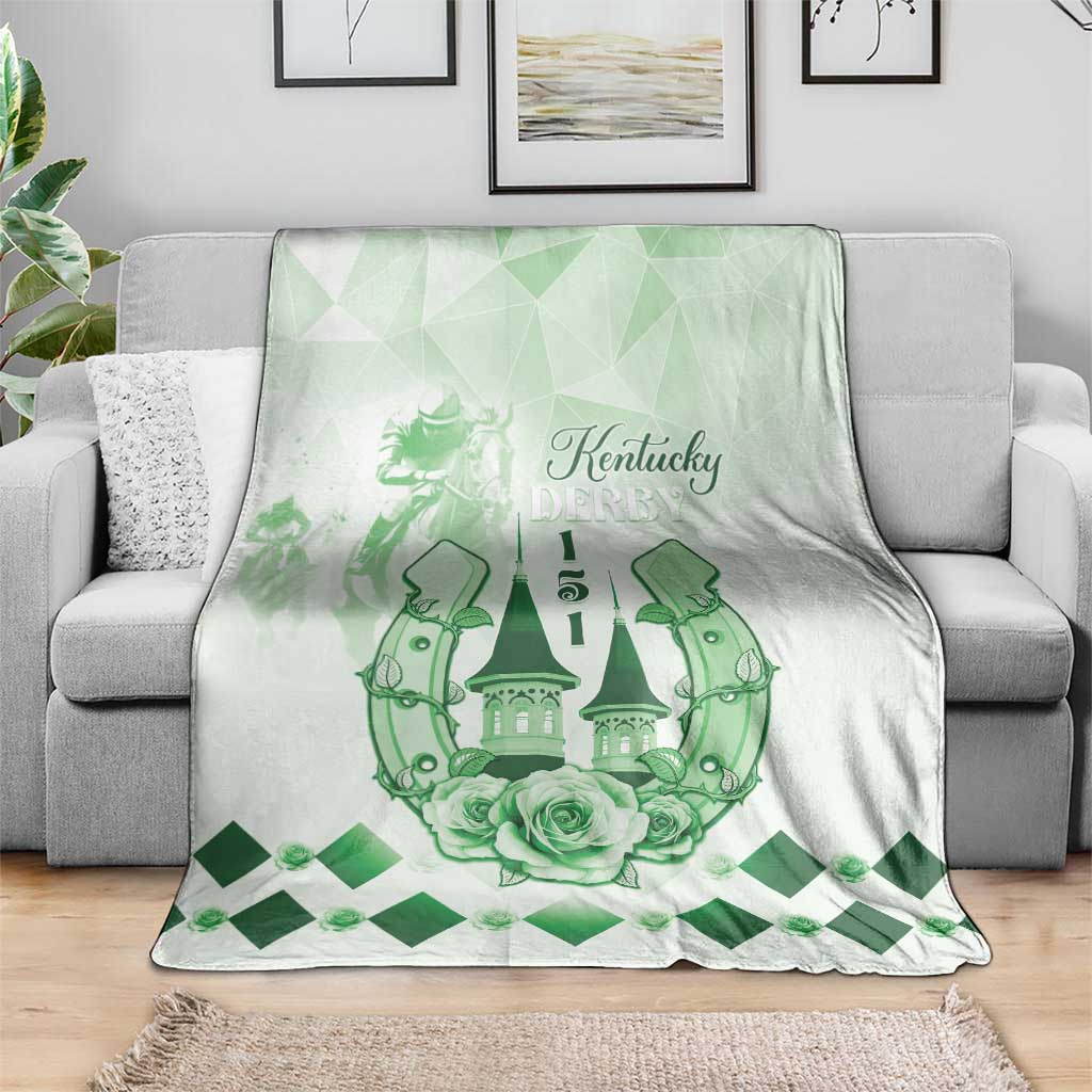 Green and white fleece blanket draped on sofa with Kentucky Derby emblem, horses, roses, diamond trim.