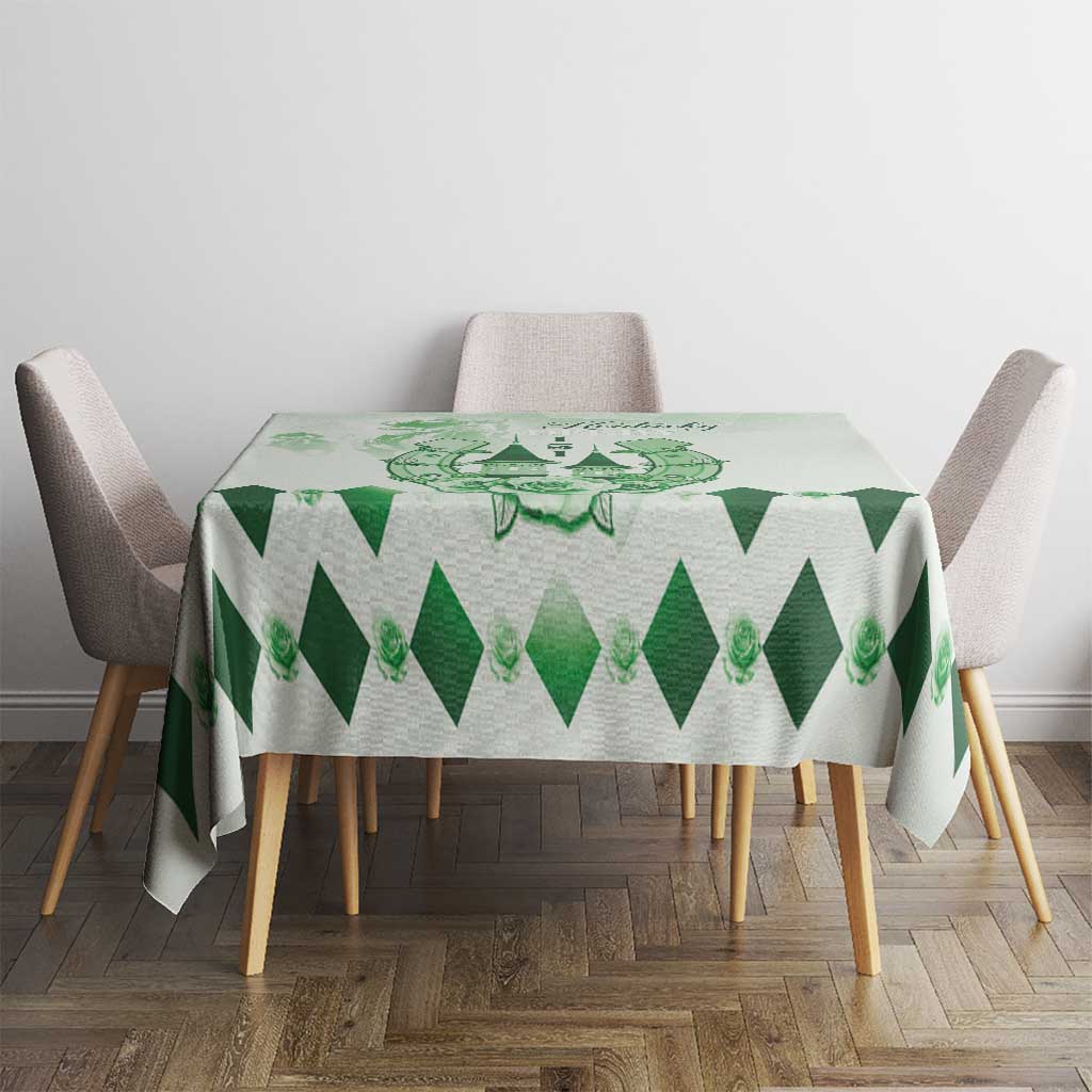 Green diamond-pattern tablecloth with central crest on round dining table