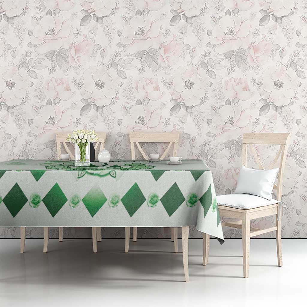 Green diamond-pattern tablecloth with floral crest on rectangular dining table