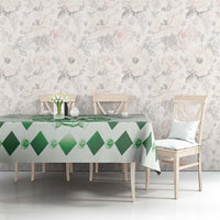 Green diamond-pattern tablecloth with floral crest on rectangular dining table