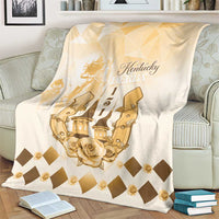 Beige throw blanket draped on a couch, featuring gold Kentucky Derby text and rose design